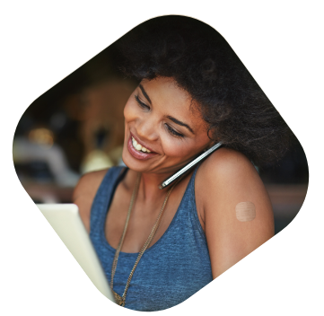 Woman on phone wearing XULANE patch on her upper arm